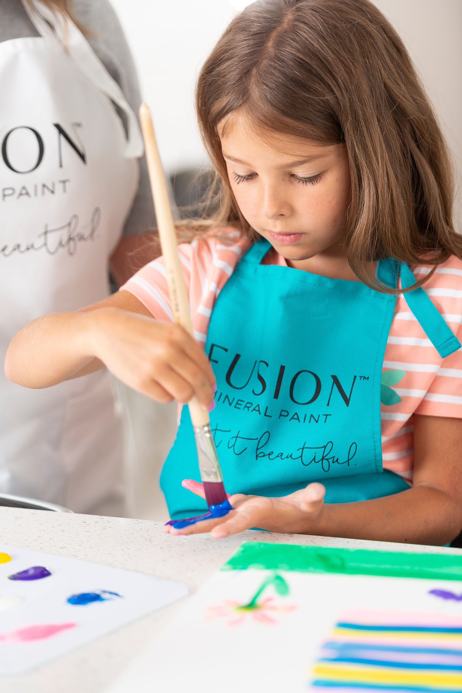 child painting while wearing a paint apronChild Sized Paint Apron